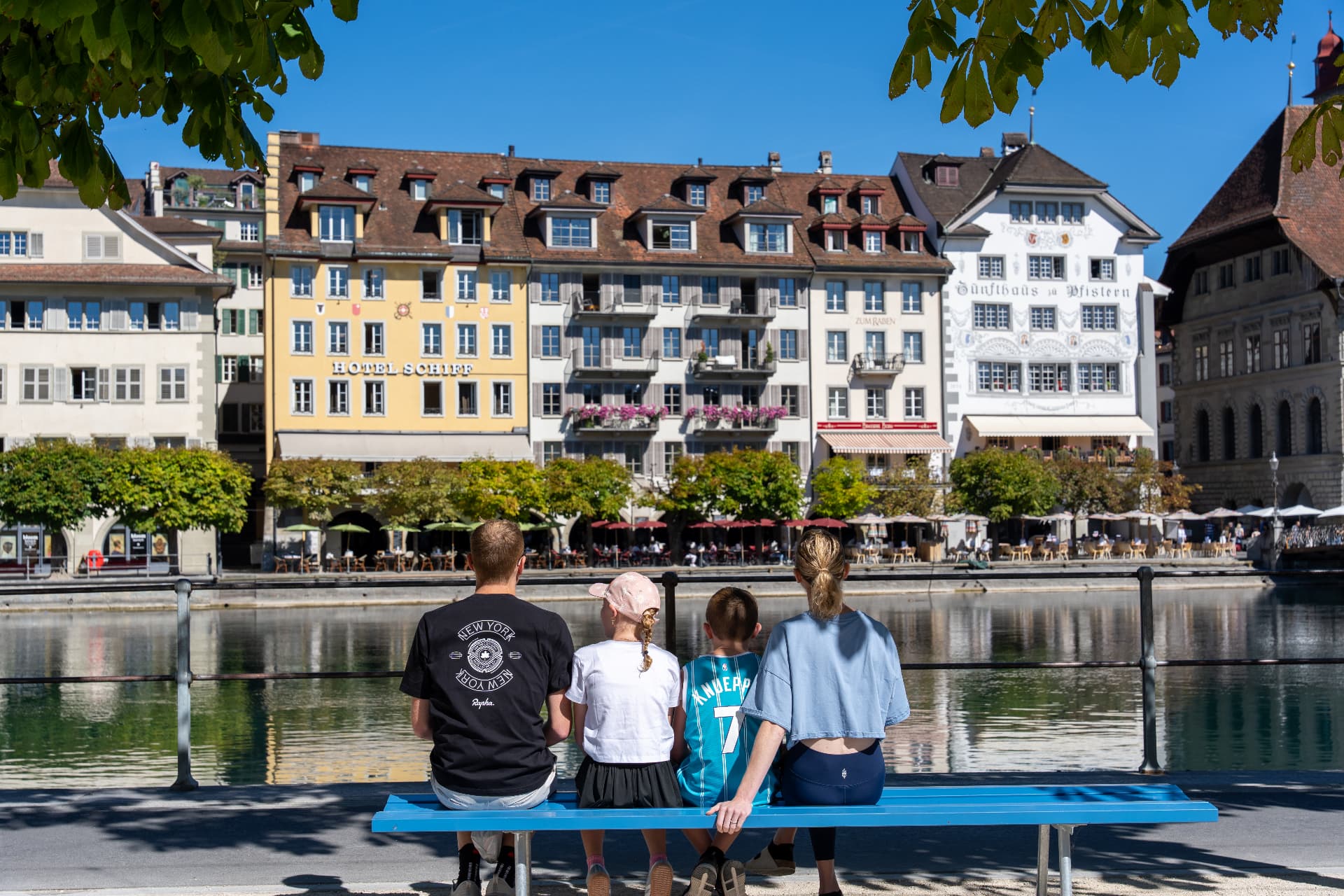Family sitting on a bench along the Reuss river
